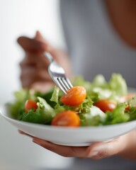 Close up of woman eating healthy salad, focus on fork and fresh vegetables, clean eating concept
