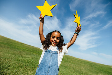 Girl enjoying imaginative play in sunny open field