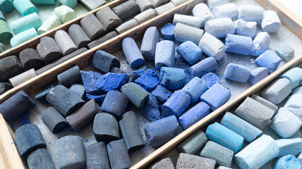 Blue gray soft pastels chalk collection in wooden case. Art supplies for pastel painters, painting and drawing tools. Painter multicolor background