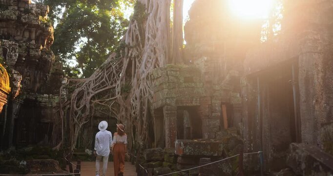 Tourist Couple Wandering Ta Prohm Temple Ruins Under Golden Sunlight