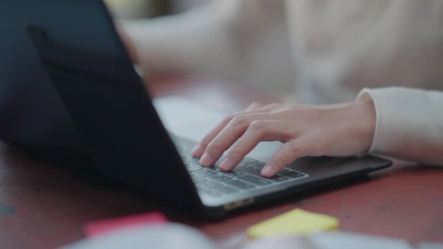 Collaborative learning concept featuring two asian girls sitting on grass under tree exchanging ideas and researching information for university thesis ensuring academic success outdoors