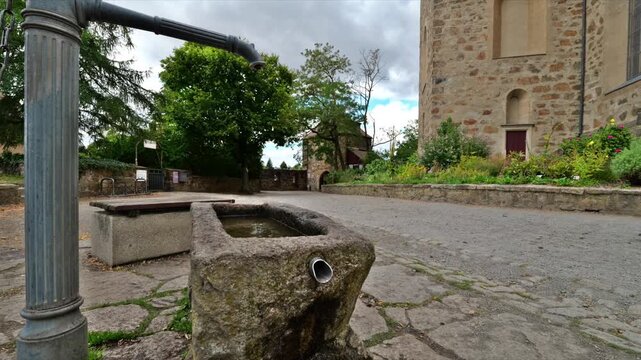 Historic fountain with old pump next to Michaeliskirche in Bautzen, Germany. Stone trough with flowing water