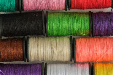 Colorful spools of thread as background. Closeup.