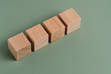 Wooden blocks on green background, copy space, business concept.