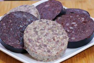 Selection of slices of raw haggis and black pudding on a plate