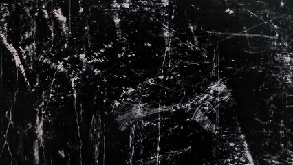 Black grunge texture background with dust, scratches, and noise. Abstract dirty black surface with white scratch marks. Grunge overlay background with copy space.