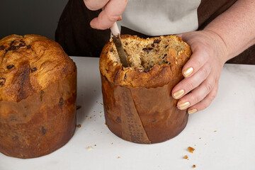 A confectioner removing the center of a panettone to prepare it for filling.