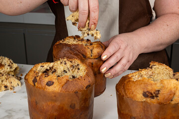 A confectionerremoves the center of the panettone by hand to fill it.