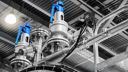 A top-down view of a large industrial food processing machine in a factory or plant. The machine has many pipes, valves, instruments, and equipment.