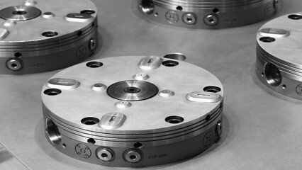 Metal round complex parts lie on the work table at metal processing and industrial plant or factory, industrial concept background.