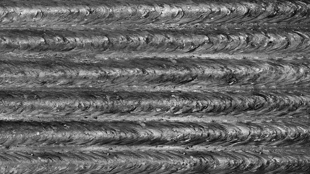 Metallic rough abstract textured background of horizontal parallel welded seams, industrial concept background