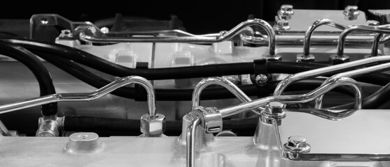 Beautiful modern car engine close-up, the engine is new and shiny made of stainless steel with tubes and wires.