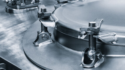 Part of a large chemical pharmaceutical machine, a stainless steel container covered with a bolted...