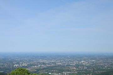 Fototapeta premium Panoramic view of large city and surrounding landscape under clear blue sky