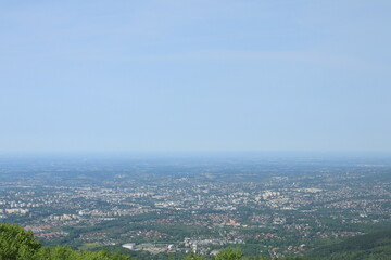Naklejka premium Wide panoramic view of city and surrounding countryside under clear blue sky