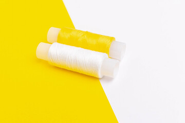 Spools of Yellow and White Thread on Contrasting Yellow and White Background