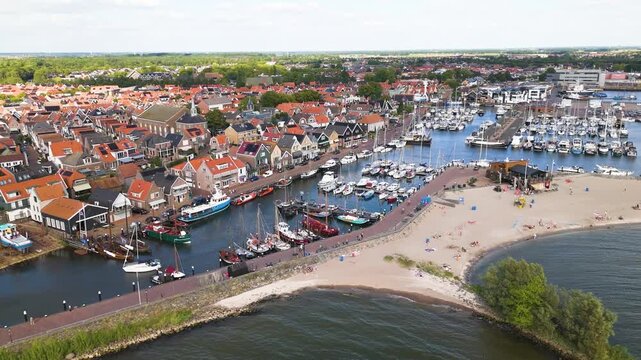 harbor filled white sailboats traditional fishing vessels these moored sandy beach red roofed houses urk netherlands near red-roofed boat marina nautical navigation 