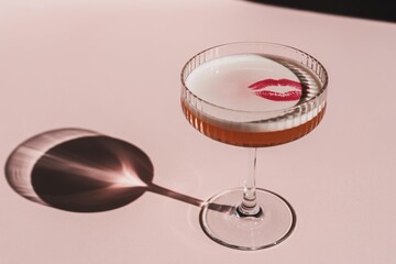 Luxury Cocktail Glass with Red Lip Print on Soft Pink Background, Elegant Bar Concept