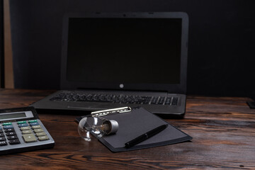 Close up of light bulb on open notepad with calculator and blurred laptop in background. Workplace of a creative person.