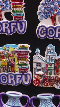 View of traditional tourist souvenirs and gifts from Kerkyra, Corfu island, Ionian sea, Greece, fridge magnets with text "Corfu","Greece" and key ring keychain, in local vendor souvenir shop kiosk