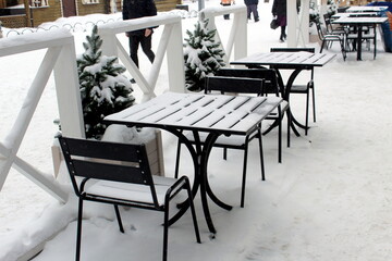 Summer cafe covered with snow during winter.