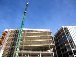 building under construction with green crane