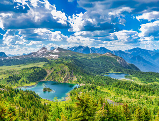 Breathtaking high-angle view of multiple turquoise lakes surrounded by wildflowers and snow-capped peaks at Sunshine Meadows Banff National Park