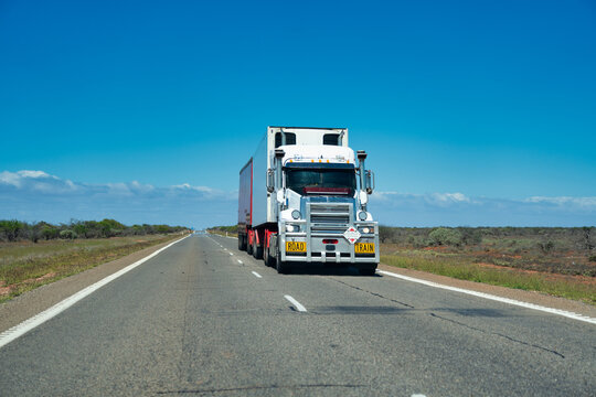 Heavy freight road train traveling along remote highways in Western Australia