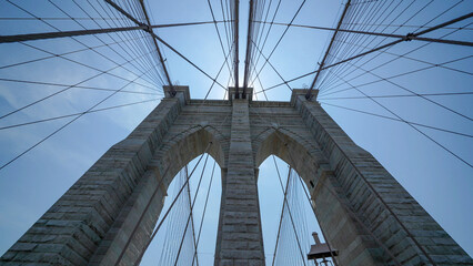 Naklejka premium Brooklyn Bridge stone pillars captured from below highlighting structural details and grandeur