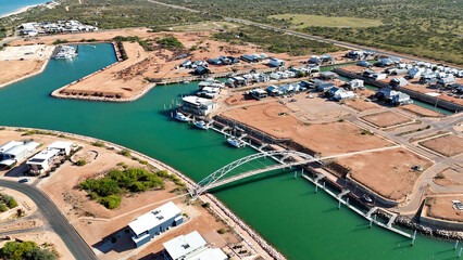 Scenic aerial perspective of Exmouth port Western Australia with piers, vessels, and bright sunshine