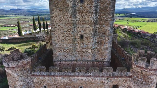Ascending drone reveal of Nogales medieval castle with village and church in background