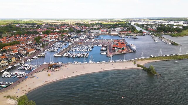 dense red roofed housing boat filled marina define coastal town sandy beach meets dark waters ijsselmeer urk netherlands red-roofed architecture nautical navigation yachting 