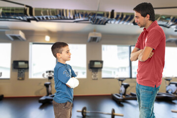 A man and a boy are standing in a gym