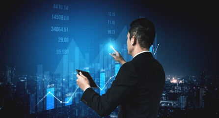A businessman examines financial data displayed on a digital screen, highlighting trends and insights against a dynamic city skyline backdrop at night. Scalp