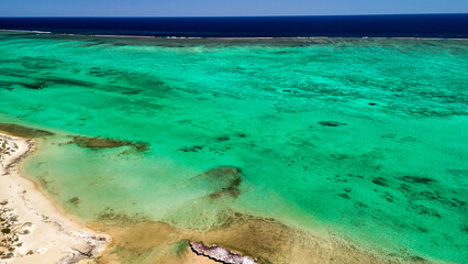 Obraz premium Drone shot of Ningaloo coastline showing lakeside beach, calm ocean, and natural surroundings