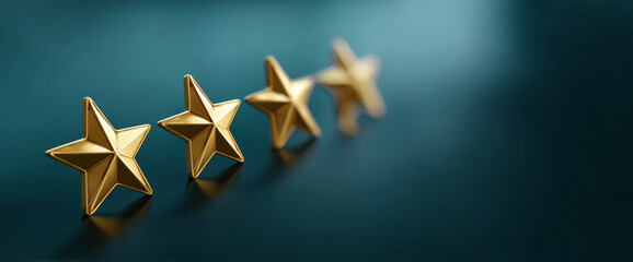 Close-up of five golden stars arranged in a row on a dark teal surface with shallow depth of field and soft lighting
