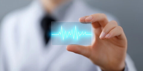 Doctor holding a transparent card displaying a glowing blue electrocardiogram waveform