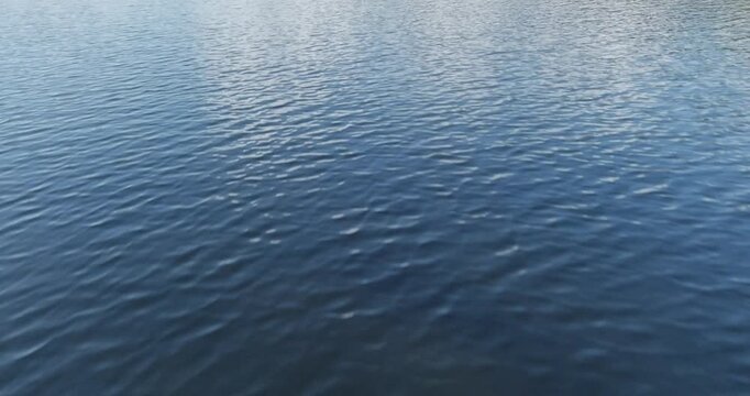 Aerial view of a body of water with gentle ripples on its surface in summer, Pentala, Espoo, Finland.