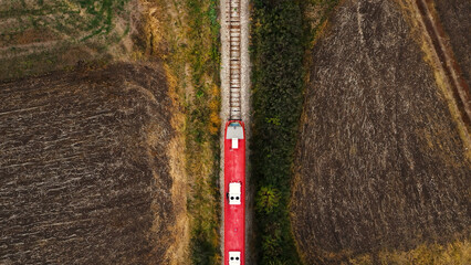 Aerial view of passenger train on railway through autumn countryside landscape, top view © Bits and Splits