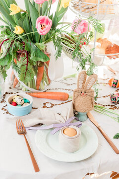 Easter table close up detail. Easter bunny egg cosy and folded napkin decorations for festive Sunday breakfast