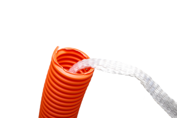 Isolated innerduct conduit with pull string, close up. Conduit system for cable management or cable pulling for fiber optics or high-speed internet upgrades. Orange pipe with string. Selective focus.