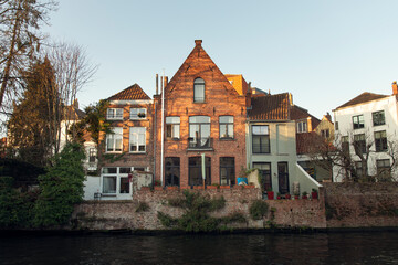 Historic European canal houses in Bruges with brick gabled facade and riverside terrace in warm evening light.jpg