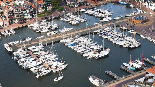 dozens white yachts sailboats neatly arranged rows along stone piers marina located next historic district urk netherlands to nautical navigation yachting coastal town marine perspective 