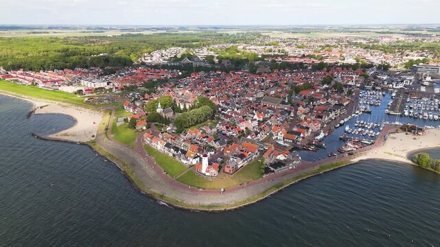 orange roofed houses white lighthouse define coastal point harbor filled boats along ijsselmeer urk netherlands wide aerial shot orange-roofed iconic structure 