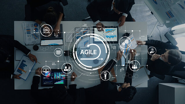 A collaborative business team engages in agile methodologies, analyzing data and strategies using digital interfaces, showcasing modern teamwork and innovation. Trope - Powered by Adobe