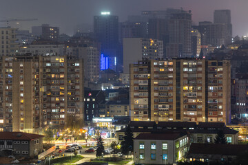 Obraz premium Night panorama of capital city capturing residential architecture, apartment buildings, warm window lights and urban mood, Pristina, Kosovo
