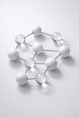 Obraz premium Clean white molecular structure model with interconnected opaque and transparent spheres on minimalist white surface, chemical concept, science visualization, modern scientific design.