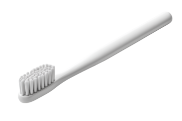 Minimalist manual toothbrush lying flat on a plain surface with no other items around during daylight hours