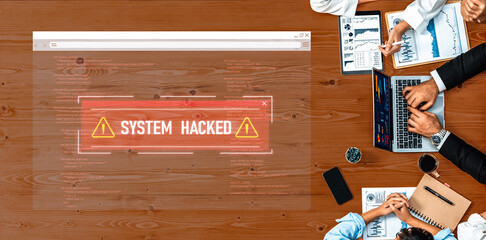 A group of business professionals discuss a serious cybersecurity threat represented by a warning message on a computer screen during a meeting. Trope