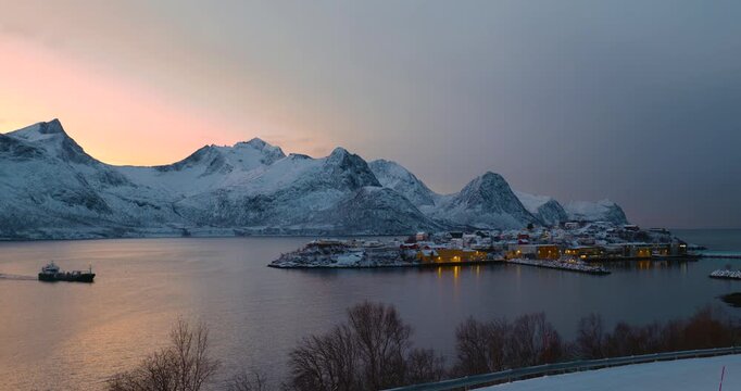 Hus&oslash;y im Winter zur blauen Stunde mit Blick in den Hafen, schneebedeckte H&auml;user und Boote im ruhigen Fjord, kalte Abendstimmung und klares arktisches Licht in Nordnorwegen